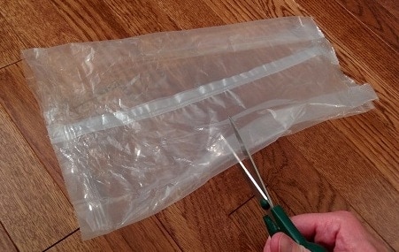 Scissors cut through plastic cereal bag.