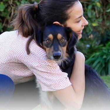 woman with dogs head on her shoulder
