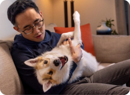A man holding his dog in his lap