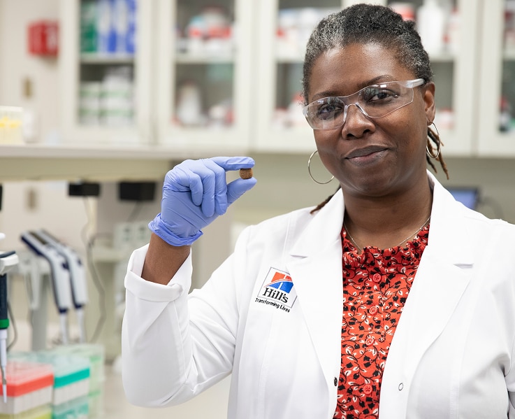 A scientist holding Hill's Pet dog food in her hand
